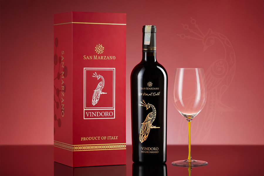 Hộp quà rượu vang Vindoro 24 Karat Gold nổi bật với sắc đỏ ruby ánh kim và biểu tượng chim công mạ vàng đầy quyền uy
